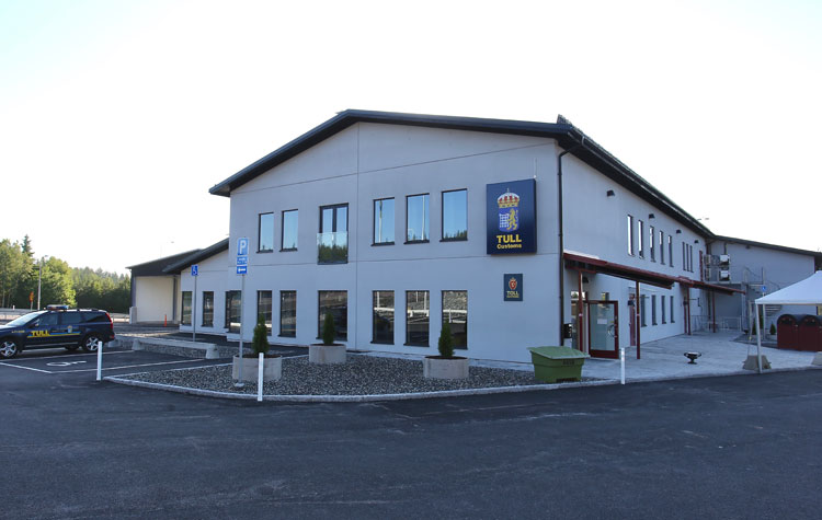 Vit byggnad med Tullverkets skylt och logotyp - den nya tullstationen.