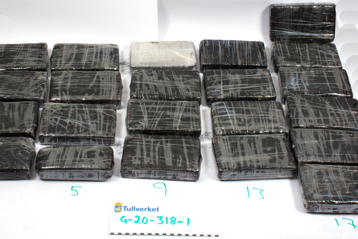Kokainbeslaget med 22 paket kokain som ligger uppradade och numrerade på ett stort vitt papper.