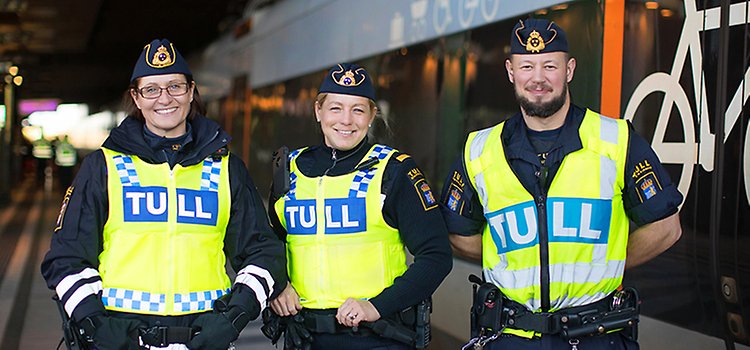 Tre glada tullinspektörer framför ett tåg. Foto: Mette Ottosson