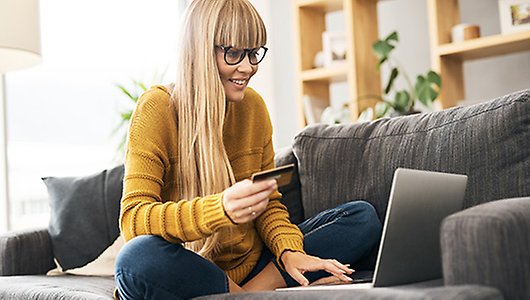 Woman looking at phone and computer